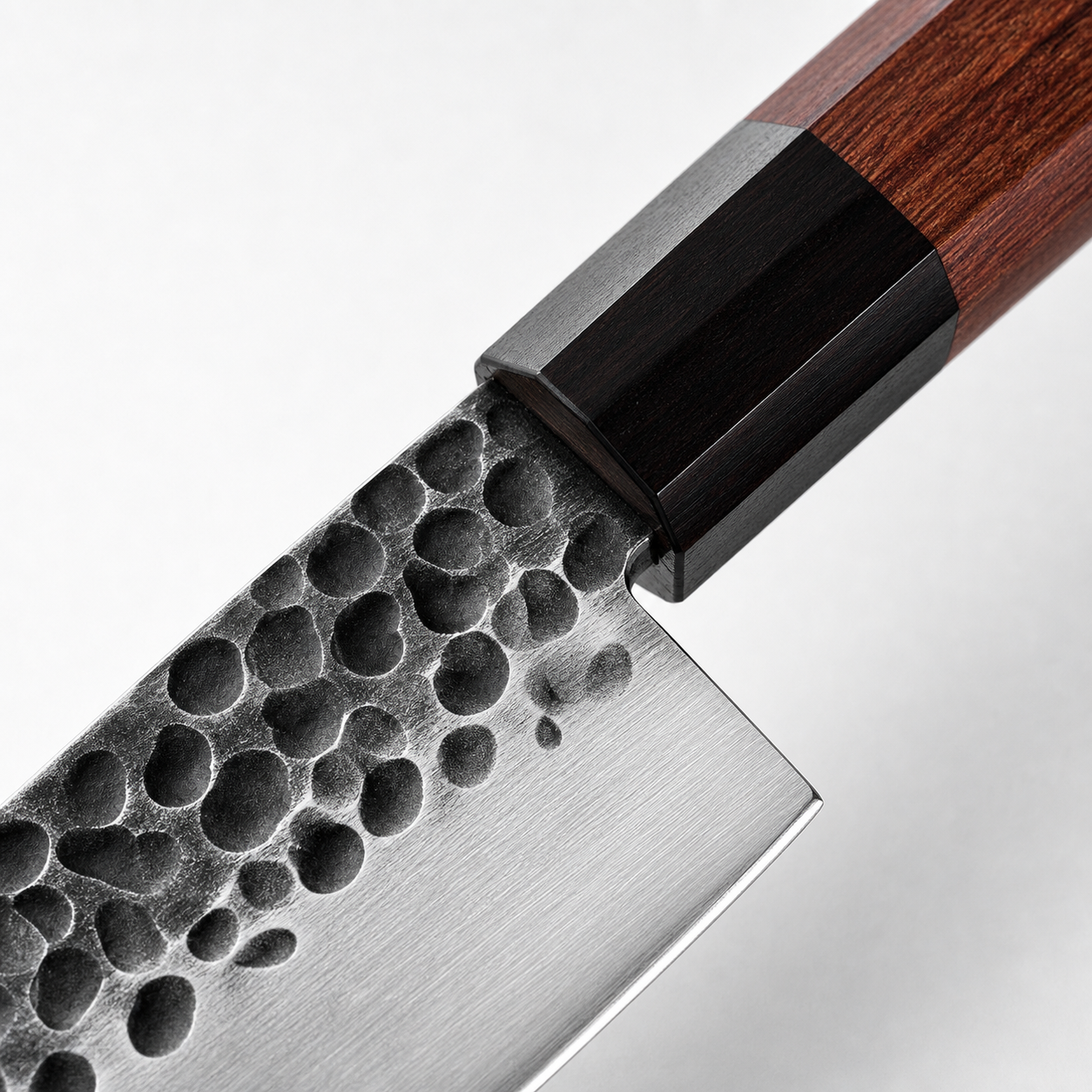 Dettaglio lama AUS10 martellata e manico in legno del coltello Santoku