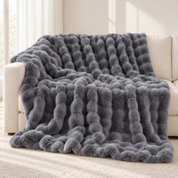 Coperta Nuvola grigia drappeggiata su un divano crema