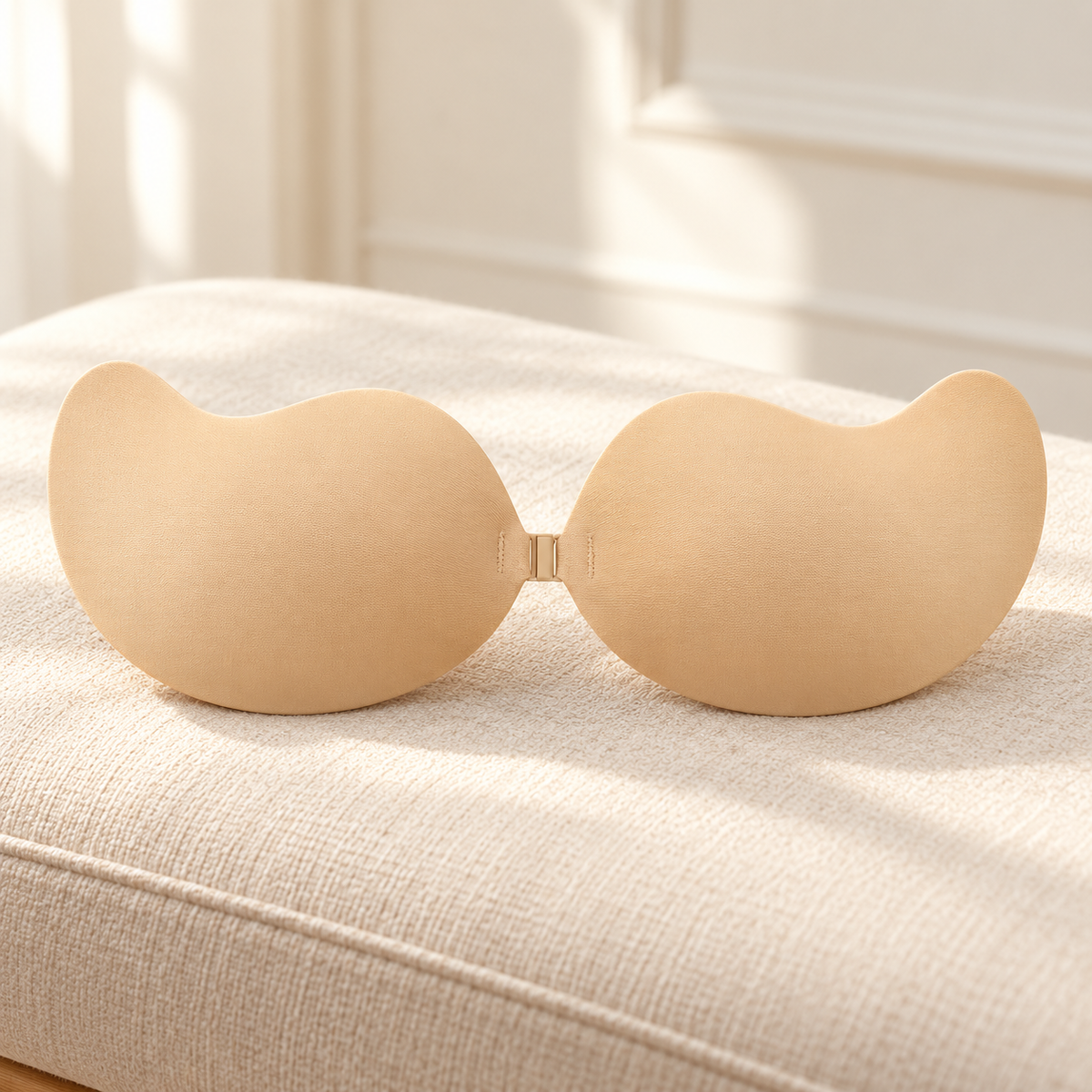 Reggiseno adesivo nudo appoggiato su una panca color crema