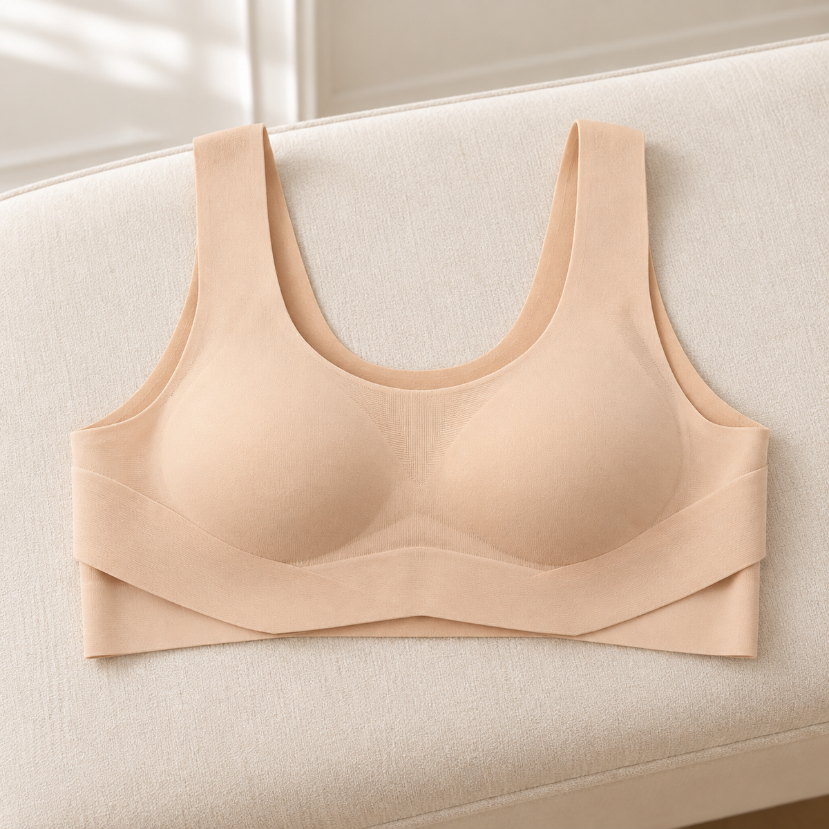 Reggiseno posturale nudo con fascia portata davanti, appoggiato su una panca crema