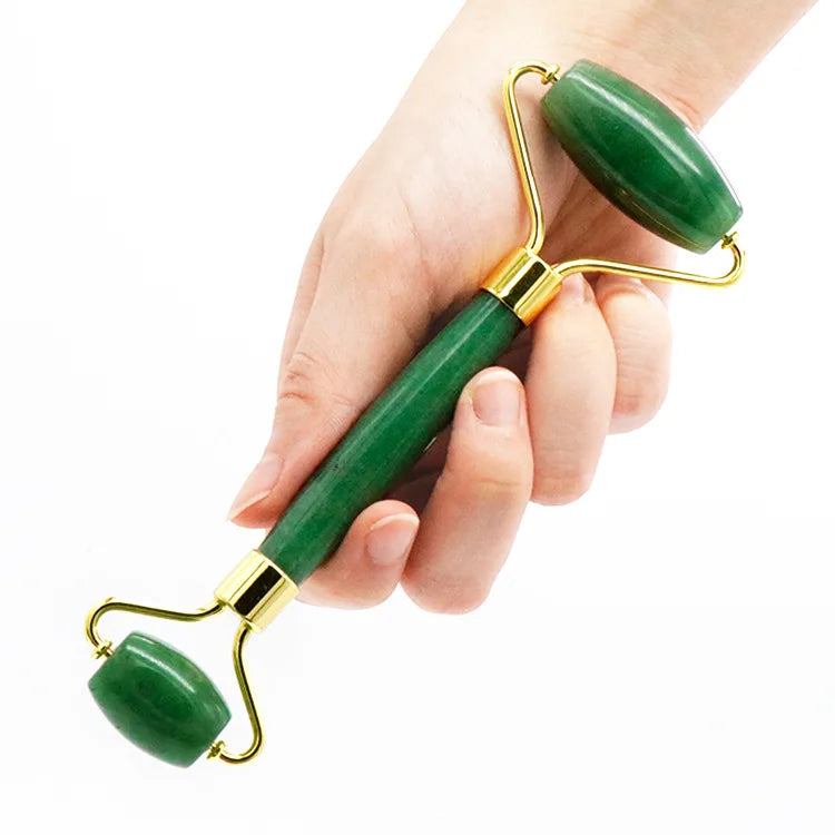 Jade roller verde tenuto in mano per massaggio viso