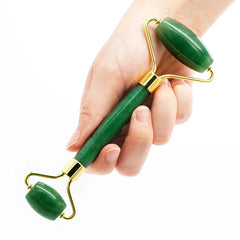 Jade roller verde tenuto in mano per massaggio viso