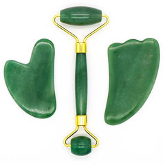 Jade roller e gua sha in pietra verde su sfondo bianco