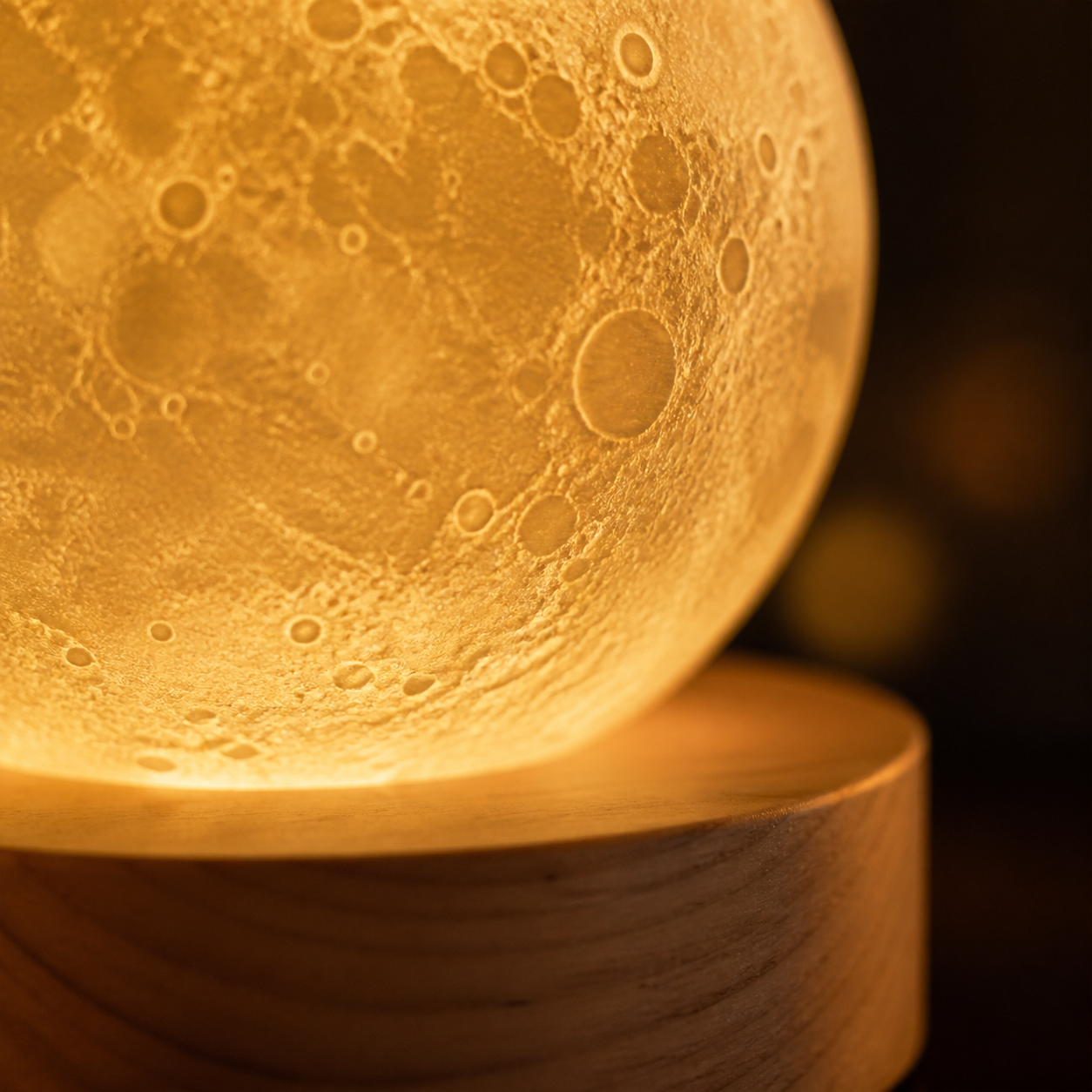 Dettaglio texture lunare e base in legno della lampada luna